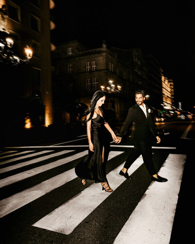 Noivos elegantes a cruzarem a rua de mãos dadas à noite, fotografia de casamento Porto por Filipe Santos Fotografia