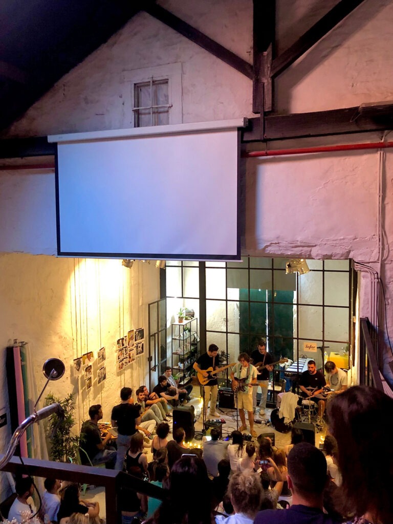 Banda a tocar em espaço acústico com público atento, sessão de eventos Filipe Santos Porto