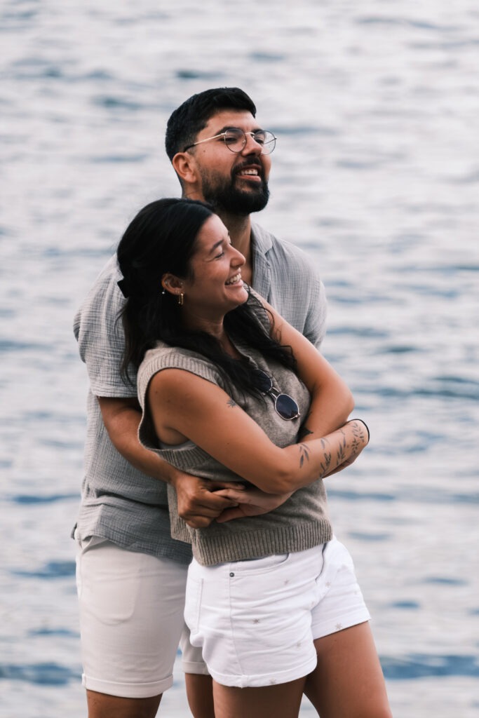 Casal em sessão de pré-casamento, no Cais de Gaia, num momento divertido com o noivo a agarrar a noiva atrás sorridentes. © Filipe Santos 2025