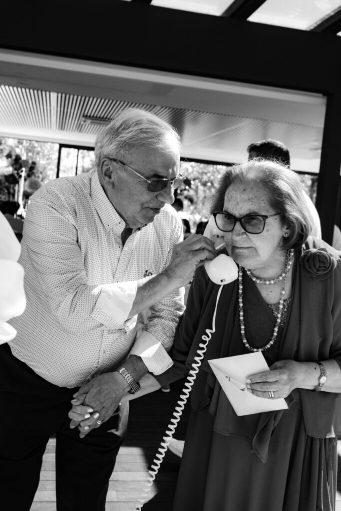 Casal idoso num momento divertido com um telefone com fio, imagem a preto e branco