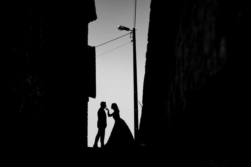 Silhuetas românticas num beijo ao pôr do sol na rua estreita do Porto