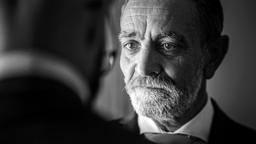 Retrato em preto e branco de homem maduro com expressão intensa e olhar penetrante, transmitindo sabedoria e seriedade