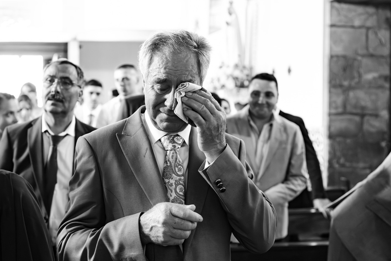 O pai da noiva emotivo na cerimónia, limpando as lágrimas com um lenço de pano