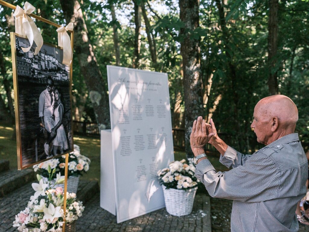 Convidado tira uma fotografia na entrada do copo de água da fotografia da sessão de pré-casamento dos noivos. 
