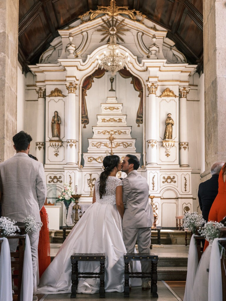 Noivos beijando-se dentro da igreja. 